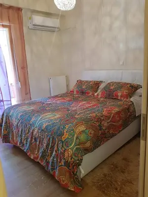 a bed with a colorful comforter in a bedroom at Urban by the Sea in Piraeus