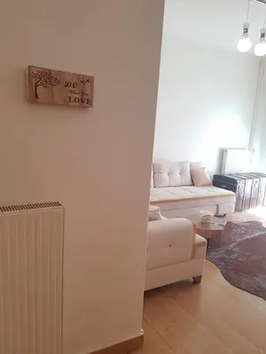 a living room with a white couch and a table at Urban by the Sea in Piraeus