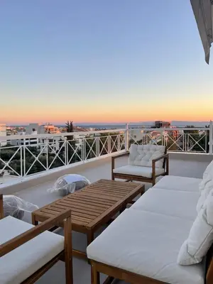 a balcony with couches and tables on a roof at Glyf Seaview Penthouse by Taurus in Athens
