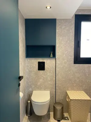 a bathroom with a toilet and a blue cabinet at Glyf Seaview Penthouse by Taurus in Athens