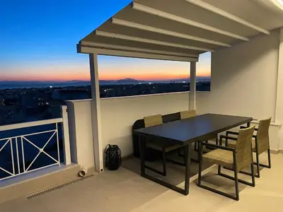 a table and chairs on a balcony with a view at Glyf Seaview Penthouse by Taurus in Athens