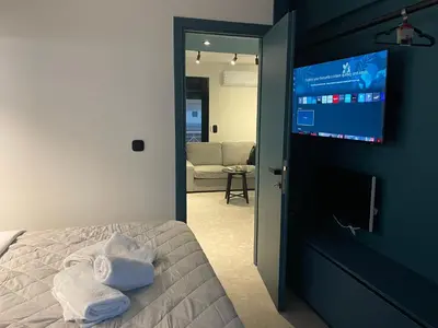 a bedroom with a bed and a flat screen tv at Glyf Seaview Penthouse by Taurus in Athens