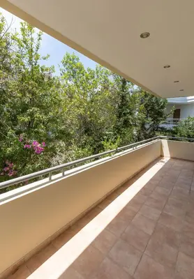 an empty balcony with a view of trees at Holiday Maisonette in Varkiza by GHH in Vari
