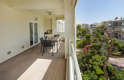 a balcony of a house with a table and chairs at Holiday Maisonette in Varkiza by GHH in Vari