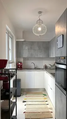 a kitchen with white cabinets and a chandelier at Stylish Apt in Paleo Faliro 300m from the beach in Athens