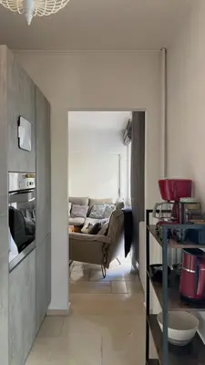 a living room with a couch and a kitchen at Stylish Apt in Paleo Faliro 300m from the beach in Athens