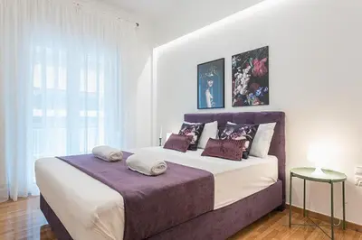 a white bedroom with a large bed with pillows at Cozy Home In Athens in Athens