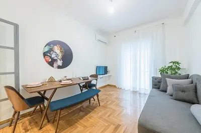 a living room with a table and a couch at Cozy Home In Athens in Athens