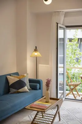 a living room with a blue couch and a table at SpyrouTrikoupi36-Cozy 1BDR Apartment near Archaeol in Athens