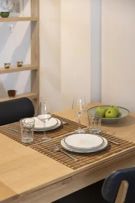 a table with glasses and plates and a bowl of apples at SpyrouTrikoupi36-Cozy 1BDR Apartment near Archaeol in Athens