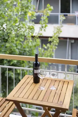 a wooden table with a bottle of wine and two glasses at SpyrouTrikoupi36-Cozy 1BDR Apartment near Archaeol in Athens