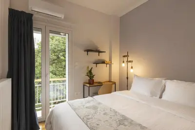 a bedroom with a white bed and a window at SpyrouTrikoupi36-Cozy 1BDR Apartment near Archaeol in Athens