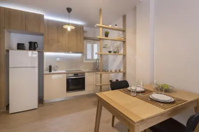 a kitchen with a wooden table and a white refrigerator at SpyrouTrikoupi36-Cozy 1BDR Apartment near Archaeol in Athens
