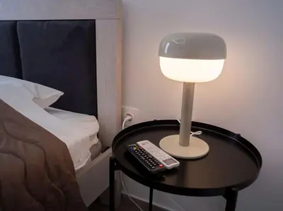 a lamp on a table next to a bed at Athens Hill of Harmony in Athens