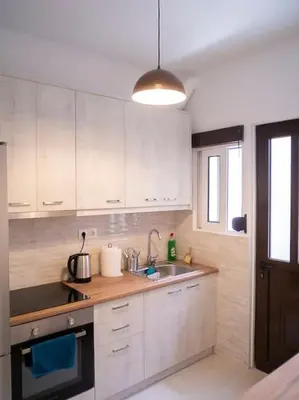 a kitchen with white cabinets and a sink at Athens Hill of Harmony in Athens