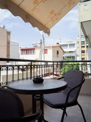 a table and chairs sitting on a balcony with a view at Athens Hill of Harmony in Athens