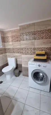 a bathroom with a washing machine and a toilet at Cozzy double bedroom Apartment in Athens