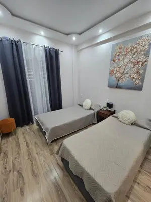 a room with two beds and a painting on the wall at Cozzy double bedroom Apartment in Athens