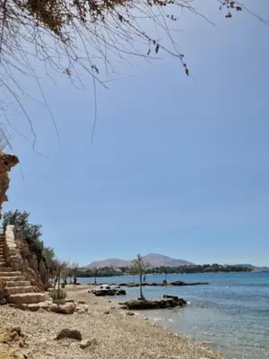 a rocky beach with a body of water at St'Georges garden house in Palaiá Fókaia