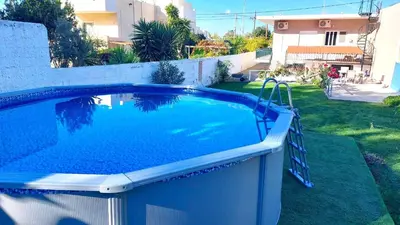 a swimming pool in the backyard of a house at Mini-villa Central Park near the beach in Lagonissi