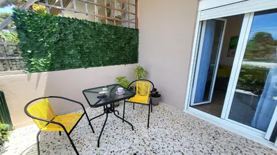 a patio with two chairs and a table on a balcony at Mini-villa Central Park near the beach in Lagonissi