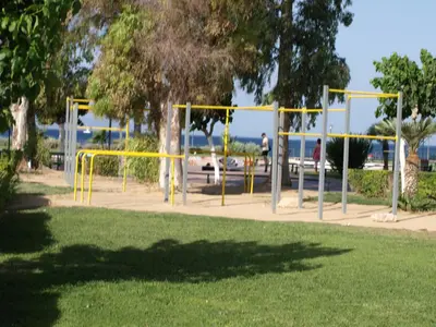 a park with yellow equipment in the grass at Alimos Kalamaki 100 meters from the Beach in Athens