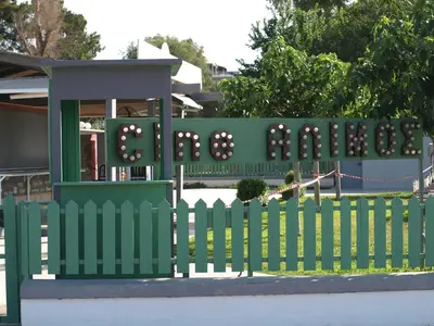 a green fence with a sign in front of a playground at Alimos Kalamaki 100 meters from the Beach in Athens