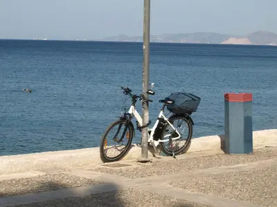 a bike chained to a pole next to the water at Alimos Kalamaki 100 meters from the Beach in Athens
