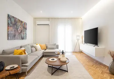 a living room with a couch and a tv at LIV - Charming 3BD in Athens Vibrant Downtown in Athens