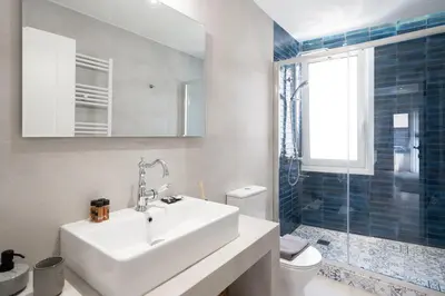 a bathroom with a sink and a toilet and a window at LIV - Charming 3BD in Athens Vibrant Downtown in Athens