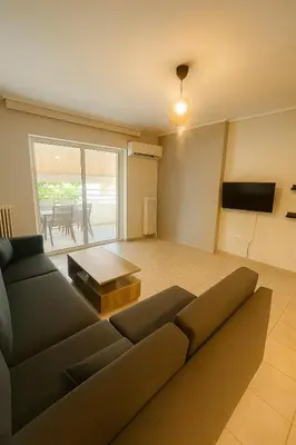 a living room with a couch and a table at Neos Kosmos Cozy Retreat - Central Comfort in Athens