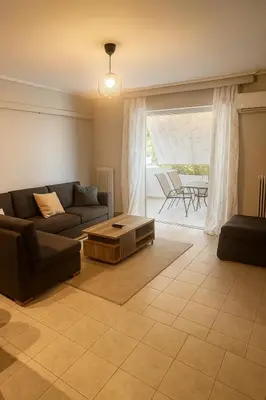 a living room with a couch and a coffee table at Neos Kosmos Cozy Retreat - Central Comfort in Athens