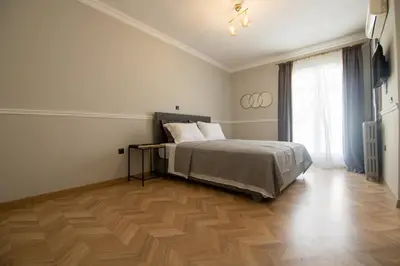 a bedroom with a bed and a wooden floor at Aerides V Suites in Athens