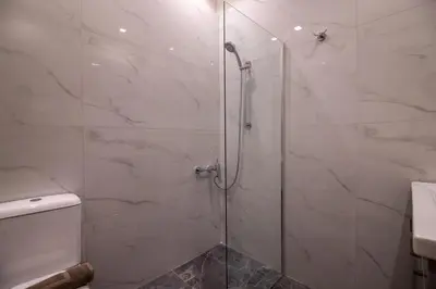 a bathroom with a glass shower with a toilet at Aerides V Suites in Athens