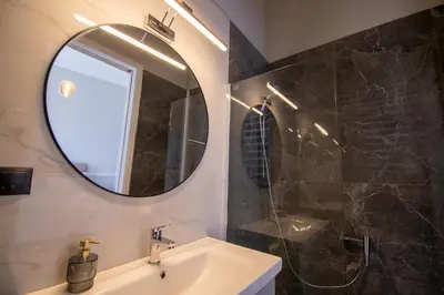 a bathroom with a sink and a mirror at Aerides V Suites in Athens