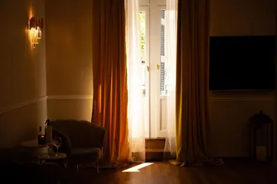 a living room with a window and a chair and a television at Aerides V Suites in Athens