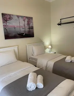 a room with two beds and a painting on the wall at Spacious apartment near Panormou metro in Athens
