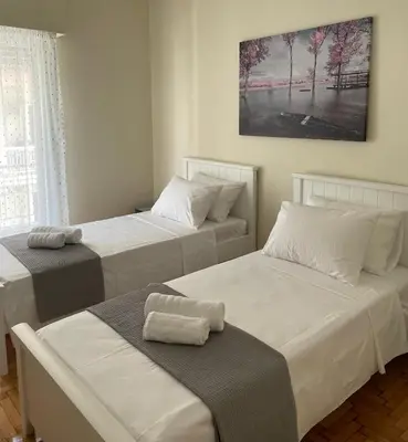 a room with two beds and a picture on the wall at Spacious apartment near Panormou metro in Athens