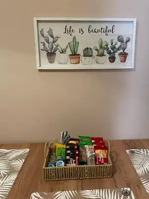 a basket of snacks on a table with a shelf with plants at Spacious apartment near Panormou metro in Athens