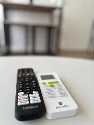 two remote controls sitting next to each other on a table at Athens penthouse with akropolis view! in Athens