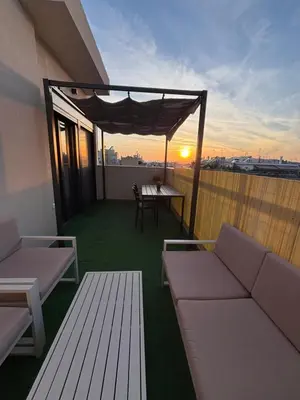 a balcony with couches and a table on a roof at Athens penthouse with akropolis view! in Athens