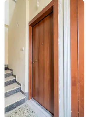 a wooden door in a room with stairs at RolandApartaments in Athens