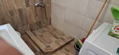 a bathroom with a shower with a wooden floor at RolandApartaments in Athens