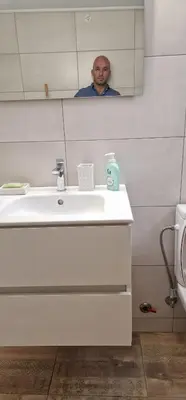 a man taking a picture of himself in a bathroom mirror at RolandApartaments in Athens