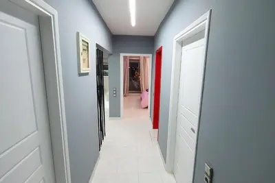 a hallway with white floors and blue walls at Panorama house near Teleperformance in Athens