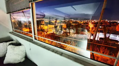 a window with a view of a city at night at Panorama house near Teleperformance in Athens