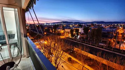 a view of a city at night from a balcony at Panorama house near Teleperformance in Athens