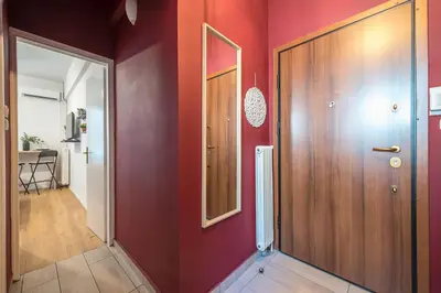 a hallway with red walls and a wooden door at Cozy Central Gem In Athens 2 min from metro in Athens