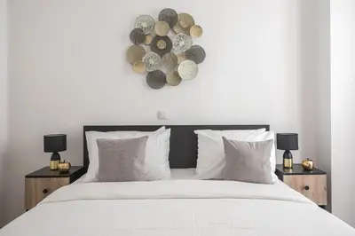a bedroom with a large white bed with two night stands at Cozy Central Gem In Athens 2 min from metro in Athens