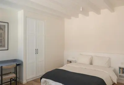 a white bedroom with a bed and a desk at Bigtrel Athens in Athens